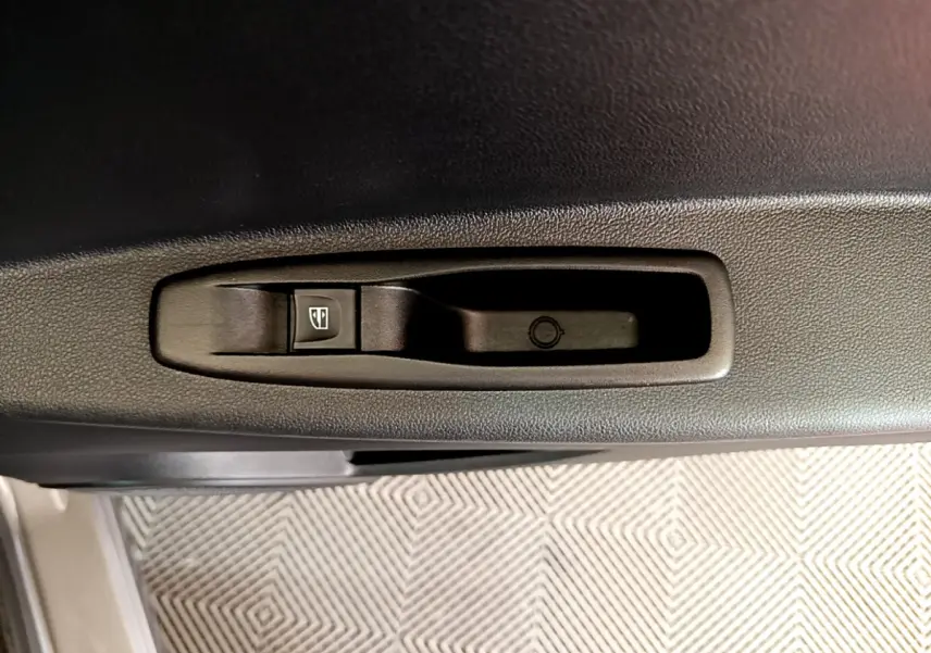 Bouton de commande de lève-vitre sur la porte intérieure côté conducteur d’un Renault Captur gris foncé 2018.