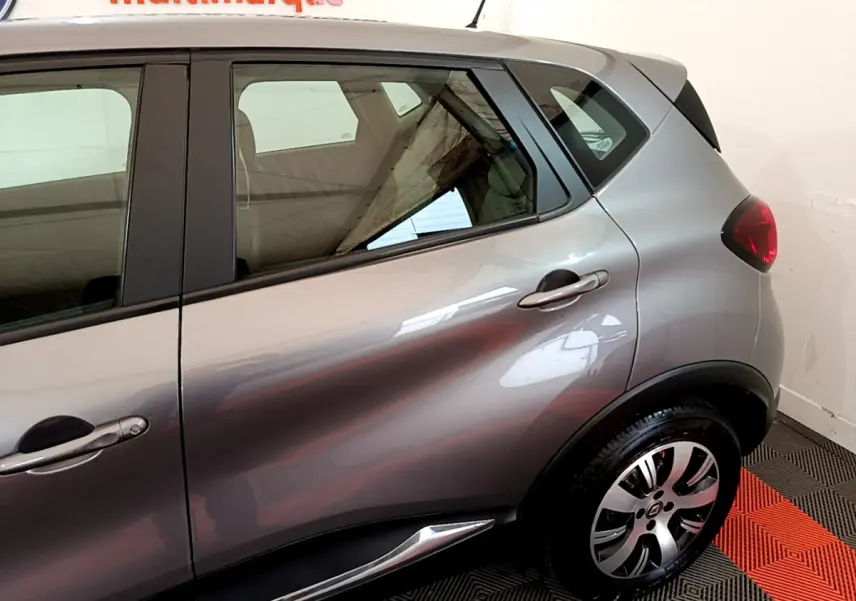 Vue latérale droite du Renault Captur Business gris foncé, mettant en valeur les lignes de caisse et la jante alliage.
