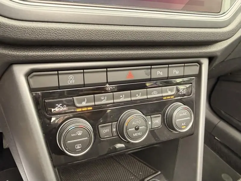 Détail du tableau de bord du Volkswagen T-Roc Cabriolet 2020, montrant la console de climatisation avec commandes digitales et boutons tactiles.