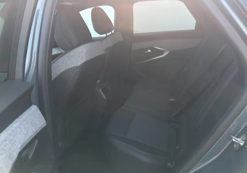 Vue intérieure côté gauche des sièges arrière noirs avec surpiqûres blanches du Peugeot 3008 bleu Ingaro 2024.
