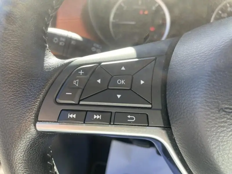 Gros plan sur les commandes multifonctions au volant côté gauche d'une Nissan Micra noire 2017, version N-Connecta.