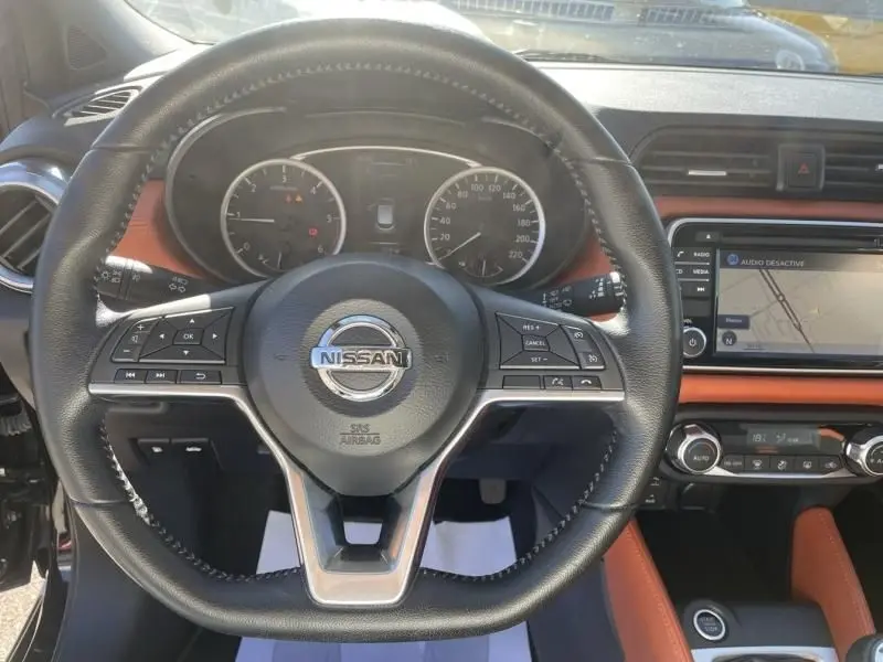 Vue intérieure centrée sur le volant noir de la Nissan Micra 1.5 DCI 2017 avec tableau de bord et écran tactile orange.