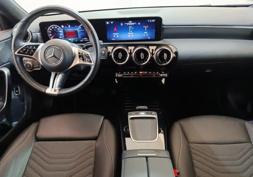 Vue intérieure avant du Mercedes GLA 250 e Business Line 2023, tableau de bord noir avec écran tactile et volant cuir multifonctions.