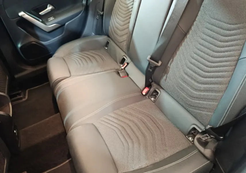 Vue intérieure côté arrière droit montrant la banquette 3 places en tissu et cuir du Mercedes GLA 250 e gris foncé.