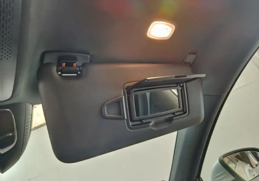Détail intérieur du pare-soleil côté conducteur avec miroir éclairé d'une Mercedes GLA 250 e Business Line 2023.