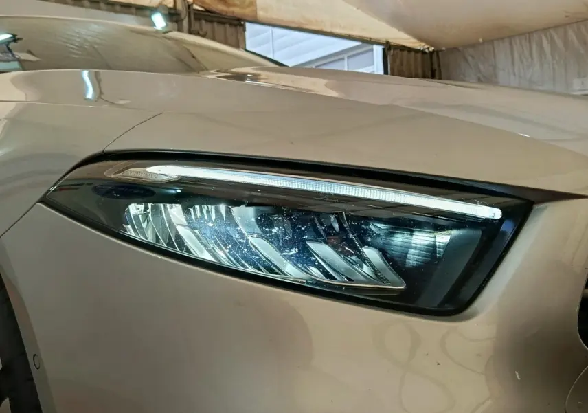 Gros plan sur le phare avant droit gris foncé du Mercedes GLA 250 e Business Line 2023 avec LED distinctive.