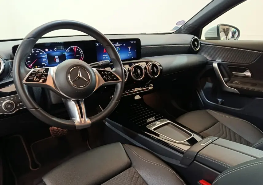 Vue intérieure côté conducteur du Mercedes GLA 250 e Business Line 2023, avec tableau de bord numérique et volant cuir noir.