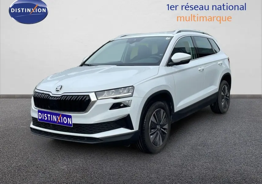SUV Skoda Karoq blanc glacier vu en 3/4 avant droit, avec calandre noire et jantes bi-ton.