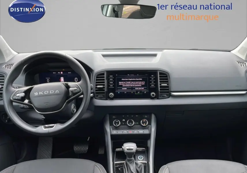 Intérieur noir du Skoda Karoq 2025, vue frontale du tableau de bord avec volant multifonction et écran central tactile.
