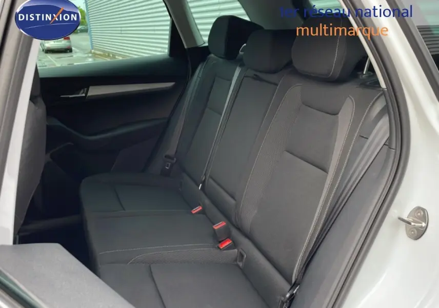 Vue intérieure côté gauche montrant la banquette arrière noire du Skoda Karoq blanc glacier 2025, finition Selection.