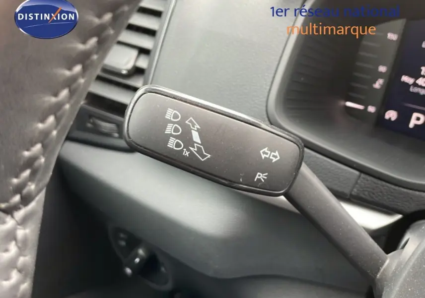 Gros plan sur la manette de clignotant à gauche dans l’habitacle d’un Skoda Karoq blanc glacier 2025.