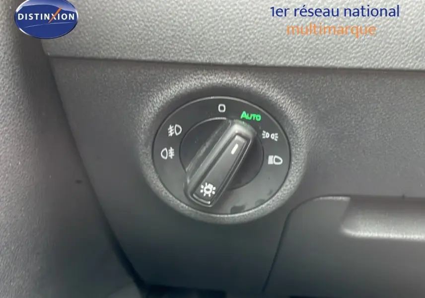 Gros plan sur le bouton de commande des phares du Skoda Karoq blanc glacier, avec mode automatique activé.