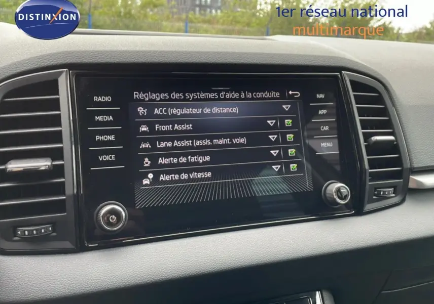 Écran central tactile du Skoda Karoq blanc glacier 2025 affichant les réglages des aides à la conduite.