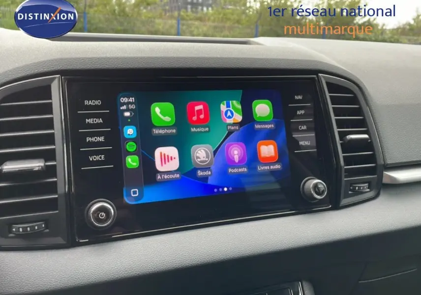 Écran tactile central du tableau de bord du Skoda Karoq blanc glacier, affichant les applications connectées.