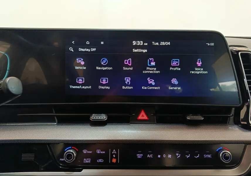 Vue rapprochée de l’écran tactile central et des commandes de climatisation du tableau de bord du Kia Sportage blanc 2022.