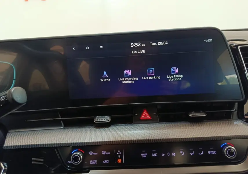 Vue rapprochée du tableau de bord numérique du Kia Sportage 2022 avec écran tactile affichant options de navigation et climatisation.