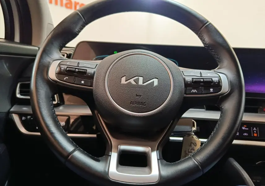 Volant en cuir noir de KIA Sportage 2022 avec commandes intégrées, vue frontale sur tableau de bord digital.