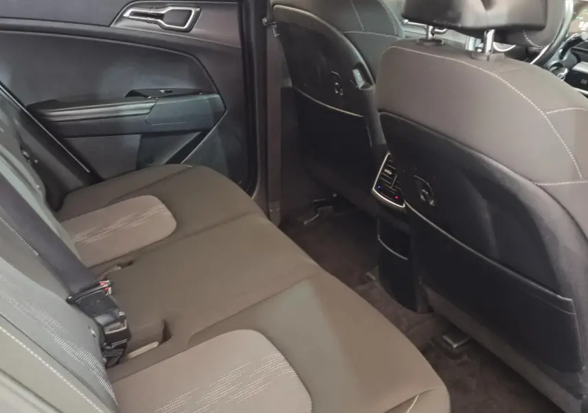 Vue intérieure arrière du Kia Sportage 2022 montrant la banquette noire et les dossiers des sièges avant.