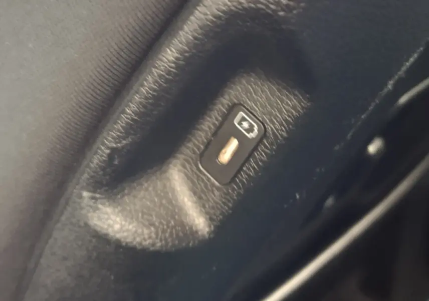 Gros plan sur le bouton de déverrouillage électrique de coffre, intérieur noir du Kia Sportage blanc 2022.