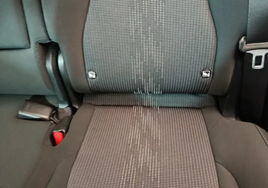 Gros plan sur la banquette arrière noire du Kia Sportage 2022, montrant les fixations Isofix et la ceinture de sécurité.
