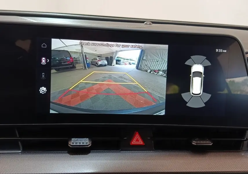 Écran tactile du tableau de bord montrant la caméra de recul et l’aide au stationnement du Kia Sportage blanc.
