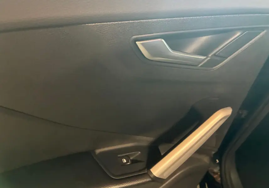 Gros plan sur la poignée intérieure et le bouton de verrouillage de la porte côté gauche d’un Audi Q2 noir de 2020.