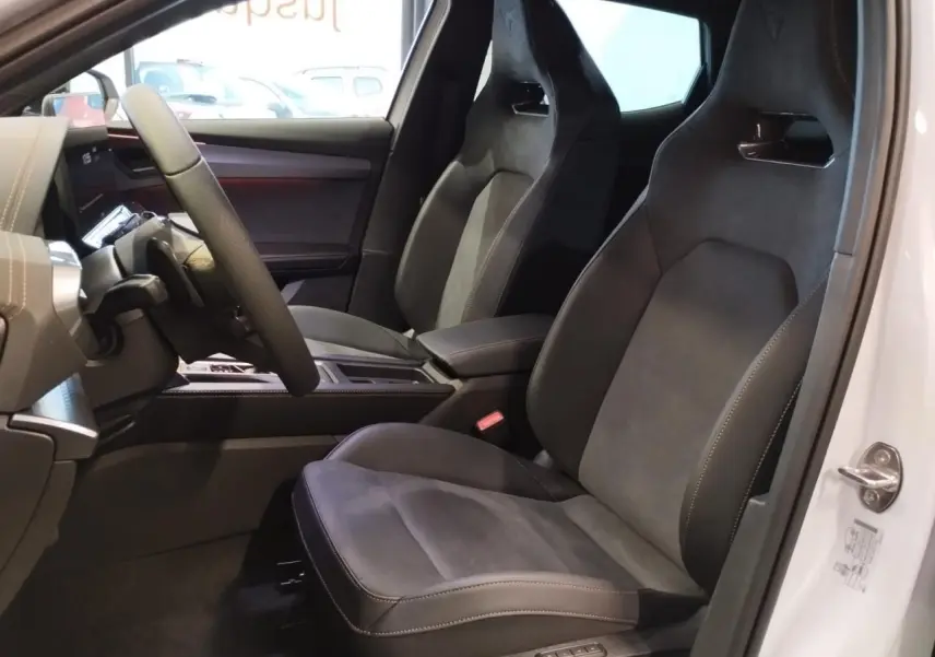 Vue intérieure côté conducteur du CUPRA Formentor blanc Nevada avec sièges baquets suédine noire et surpiqûres cuivrées.