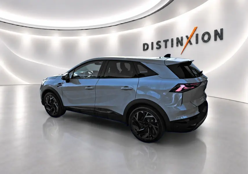 Renault Symbioz gris rafale en vue 3/4 arrière droit dans un showroom lumineux avec jantes noires distinctives.
