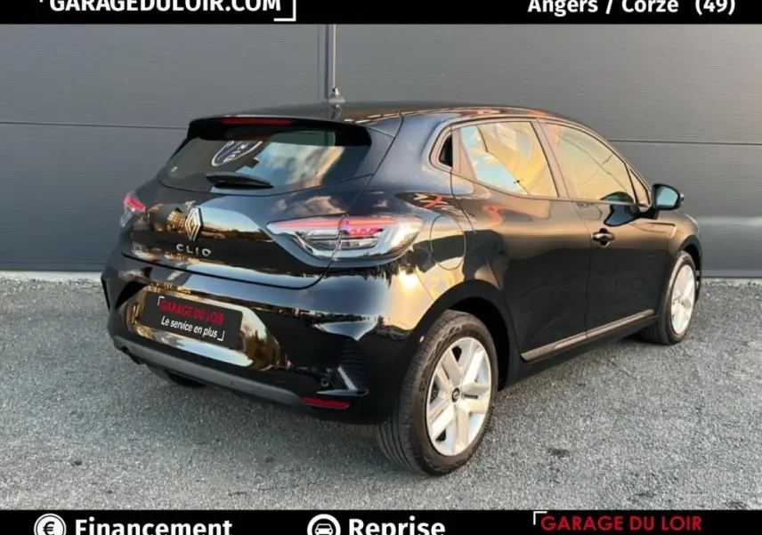 Vue 3/4 arrière droite d'une Renault Clio noire 2025 garée devant un mur gris, avec feux arrière LED visibles.