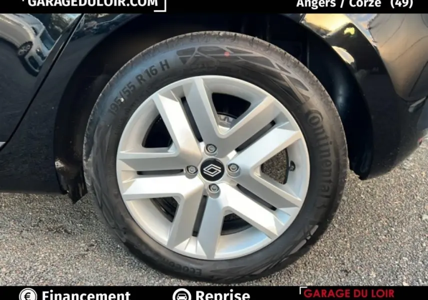 Gros plan sur la roue avant droite d’une Renault Clio noire, jante alliage argentée avec logo Renault central.