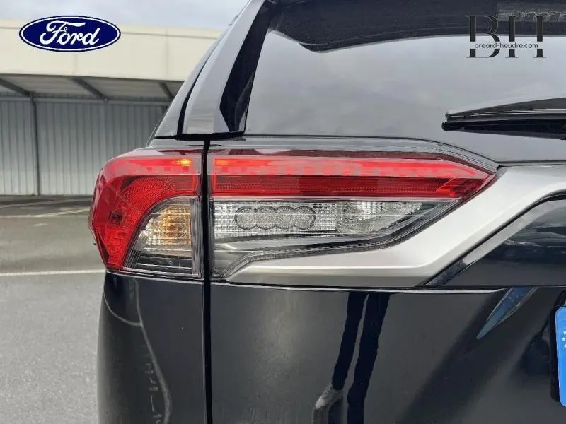 Gros plan sur le feu arrière droit noir métallisé du Toyota RAV4 2.5 Hybride 2022 avec détails chromés.
