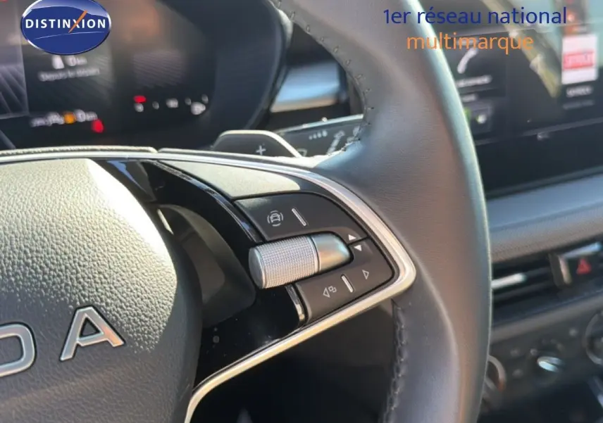 Gros plan sur le volant en cuir noir de la Skoda Fabia 2025, montrant les commandes multifonctions et partie du tableau de bord.