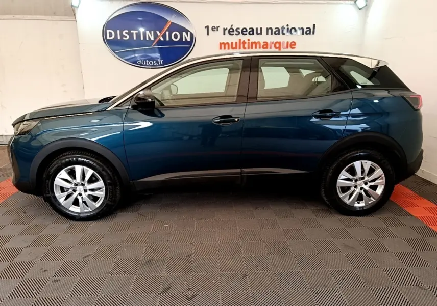 Vue latérale droite d'un Peugeot 3008 bleu 2022 en intérieur, avec toit noir et jantes argentées.
