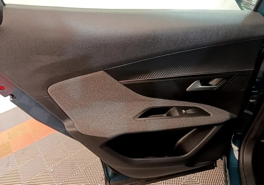 Vue rapprochée de la porte avant gauche du Peugeot 3008 bleu 2022, avec insert décoratif et poignée argentée.
