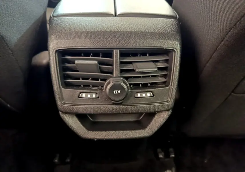Gros plan sur la prise 12V et les bouches d’aération arrière du Peugeot 3008 bleu, intérieur noir.