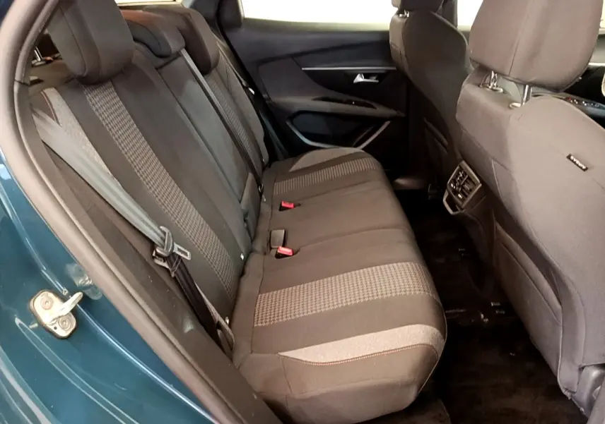Vue intérieure côté gauche des sièges arrière tissu gris du Peugeot 3008 bleu, montrant l'ouverture de porte et ceintures.