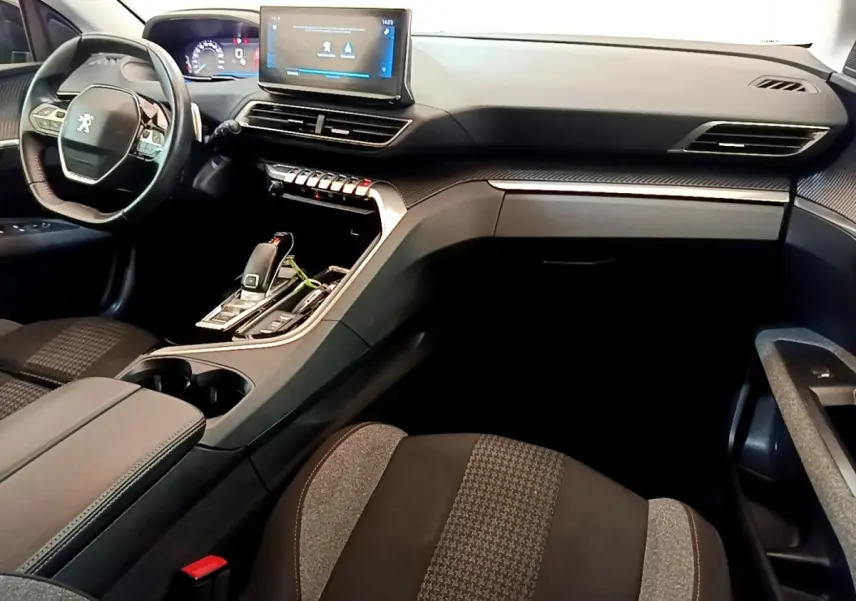 Vue intérieure côté conducteur du Peugeot 3008 bleu, mettant en valeur le tableau de bord digital et l'écran tactile central.