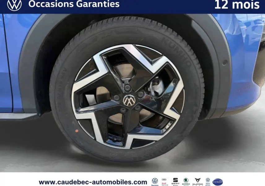 Gros plan sur la roue avant droite du Volkswagen T-Roc bleu avec jante alliage noir et argent Coventry.