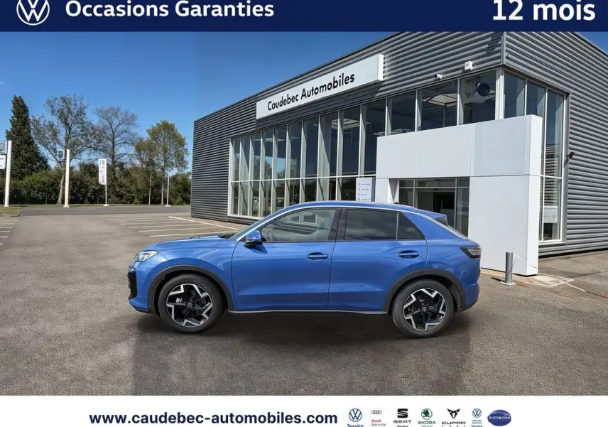 Vue latérale droite d’un Volkswagen T-Roc bleu métallisé 2026 avec jantes alliage noires et vitres surteintées.