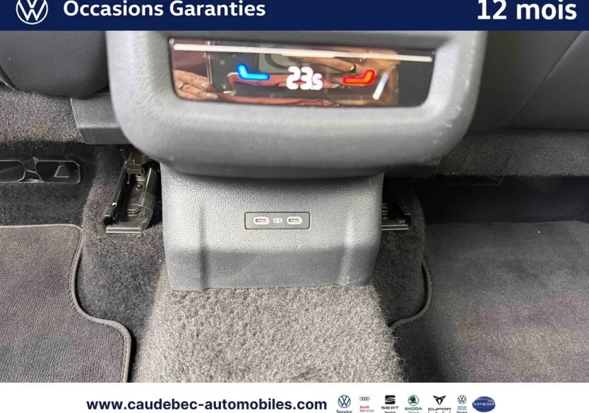 Vue rapprochée de la console centrale arrière du Volkswagen T-Roc bleu, montrant la commande de climatisation digitale à 23°C.