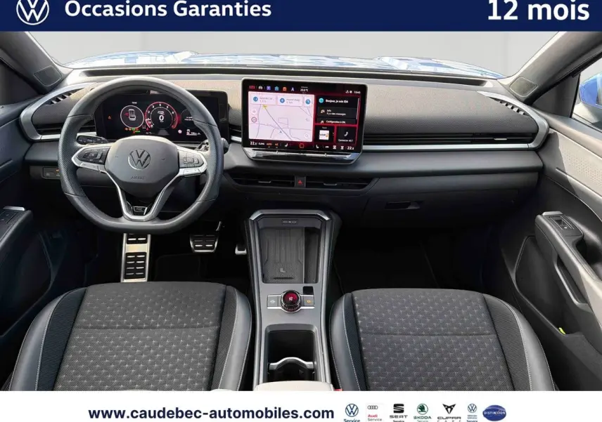 Vue intérieure avant du Volkswagen T-Roc 2026 avec tableau de bord noir et écran tactile central lumineux.