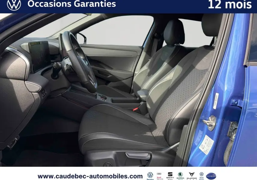 Intérieur du Volkswagen T-Roc bleu 2026, vue côté conducteur avec sièges sport noirs et volant multifonction cuir.