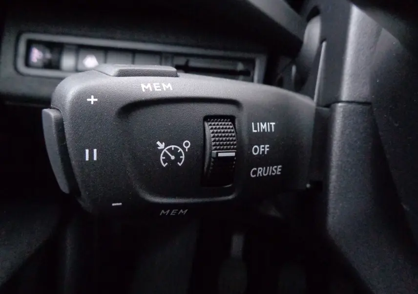 Gros plan sur la commande de régulateur de vitesse du Peugeot 3008 gris Artense, avec molette et boutons MEM, LIMIT, OFF, CRUISE visibles.