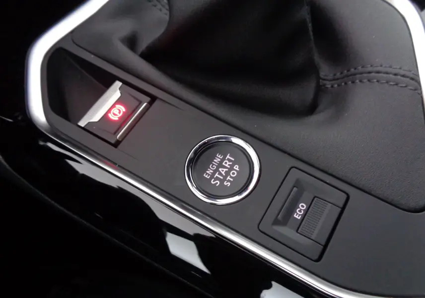 Gros plan sur la console centrale du Peugeot 3008 gris, montrant le bouton start/stop, frein à main électronique et mode ECO.