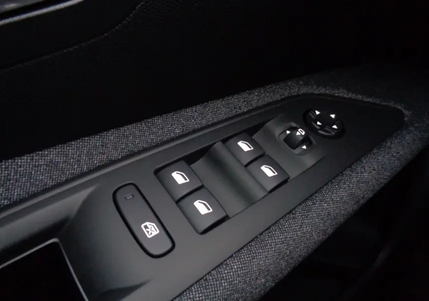 Panneau de commandes des vitres électriques et rétroviseurs sur la porte côté gauche du Peugeot 3008 gris Artense 2023.