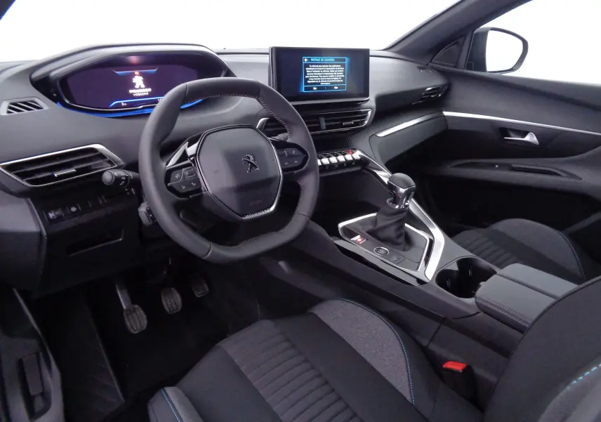 Intérieur du Peugeot 3008 2023 vu côté conducteur, avec volant compact, écran central tactile et levier de vitesse manuel.