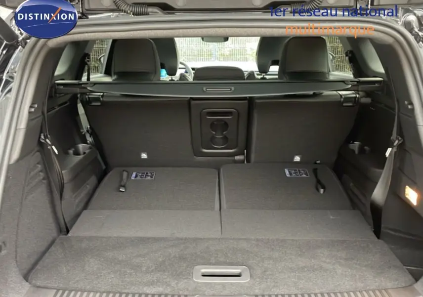 Coffre ouvert du Renault Espace noir étoile métal 2025, sièges arrière rabattus et intérieur spacieux visible.