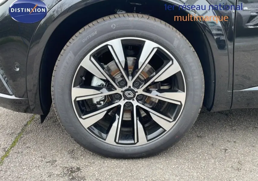 Gros plan sur la roue avant gauche du Renault Espace noir étoile métal avec jante alliage bicolore moderne.