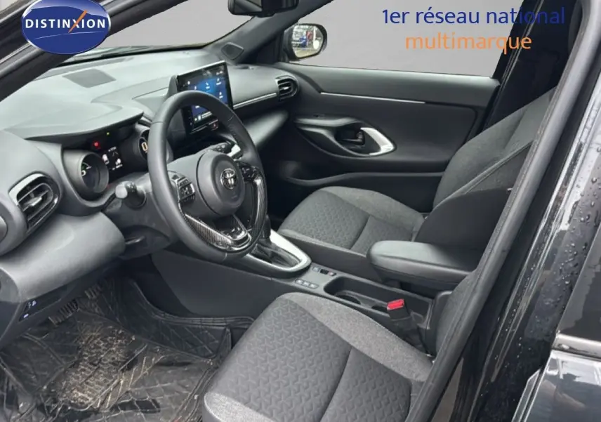 Intérieur côté conducteur de la Toyota Yaris Cross noire 2023, avec tableau de bord et sièges en tissu gris.