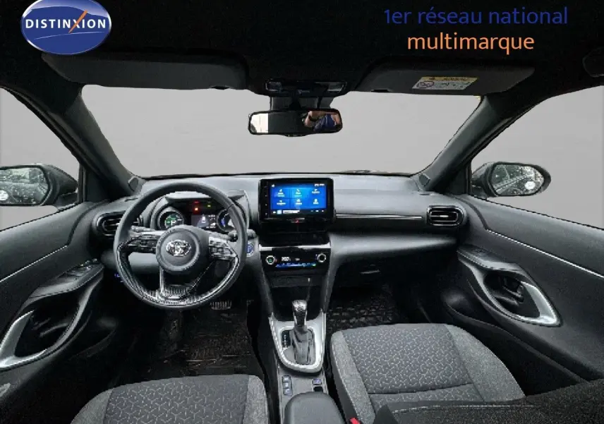 Intérieur noir de la Toyota Yaris Cross 2023 vu de face, avec tableau de bord numérique et écran tactile central.
